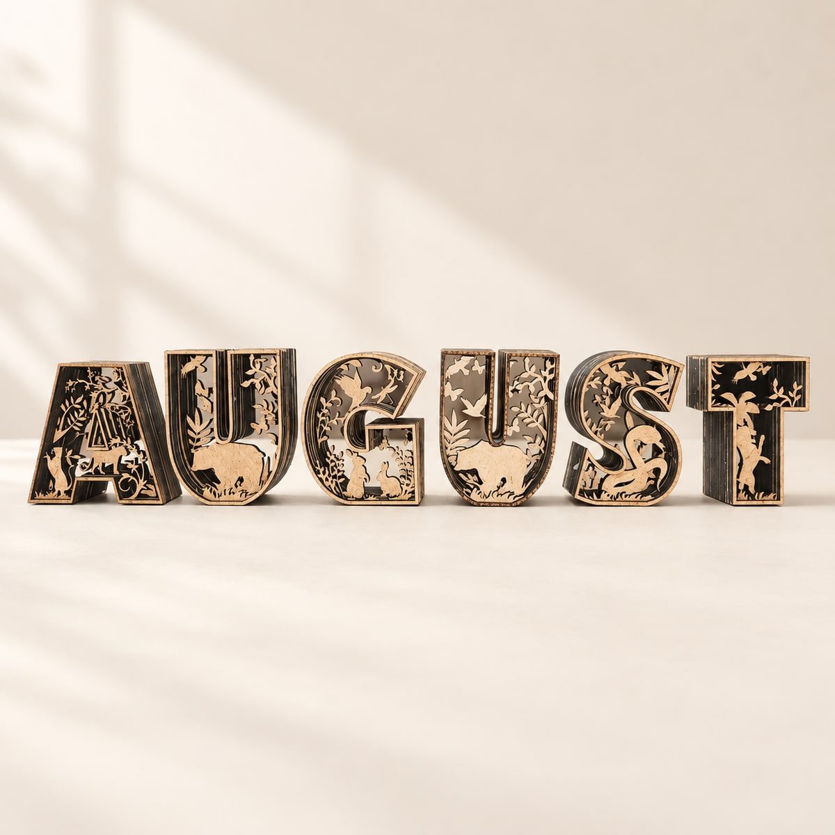Six layered wooden letters spelling August with jungle animals and foliage.
